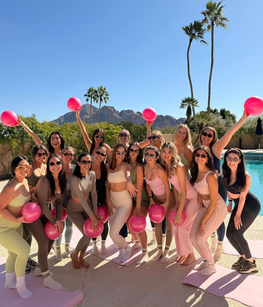 Group Pilates session with pink balls poolside in Scottsdale